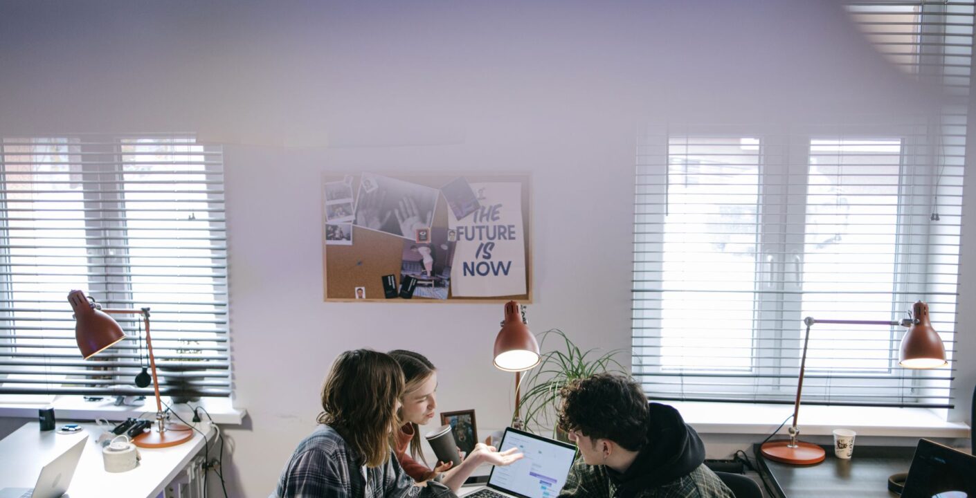 A diverse business team discussing cloud security measures around a laptop in an office setting