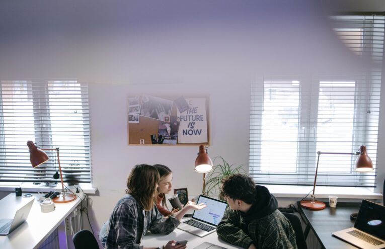 A diverse business team discussing cloud security measures around a laptop in an office setting